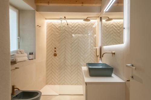 a bathroom with a shower and a blue sink at Ambiente 90 in Levico Terme