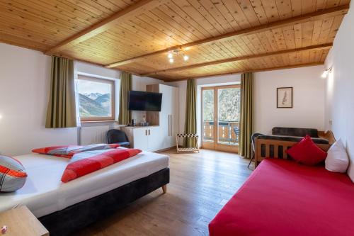 ein Schlafzimmer mit zwei Betten und roten Kissen in der Unterkunft Hotel Chavalatsch in Taufers im Münstertal