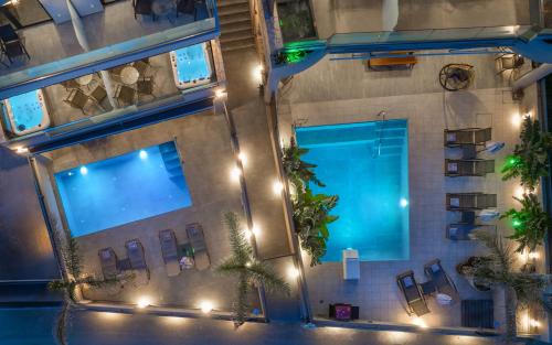 an overhead view of a pool in a building with lights at Old Cinema Suites - Stylishly Decorated Retreat with Pool or Jacuzzi by the Sea in the Heart of Laganas Βy Villa Mana Gers in Laganas