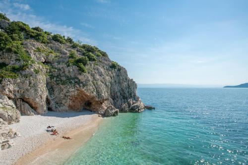a beach with people on it next to the ocean at Villa Pia by Briskva in Brseč