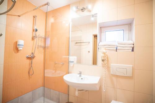 a bathroom with a sink and a shower with a sink at Hotel Ognisty Ptak in Węgorzewo