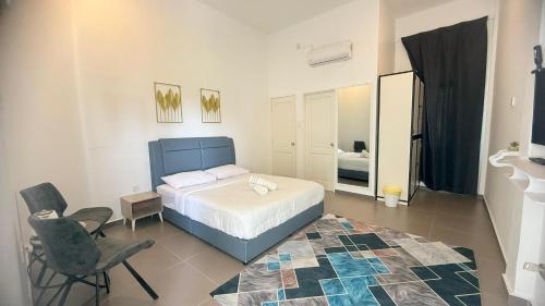 a bedroom with a bed and a chair and a mirror at Hotel O HNR INN in Kuala Terengganu