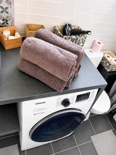 a washing machine with two towels on top of it at Côte d'Opale - Maison Cocooning Classé 3 Étoiles in Marquise