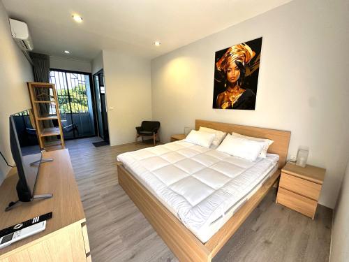 a bedroom with a bed and a flat screen tv at Acqua Rooms & Living in Koh Samui