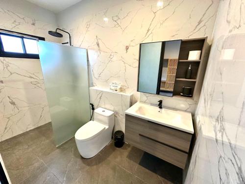 a bathroom with a toilet and a sink and a mirror at Acqua Rooms & Living in Koh Samui