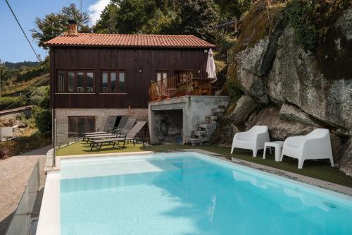 a villa with a swimming pool and a house at Casa Pinhão De Sousa in Vieira do Minho