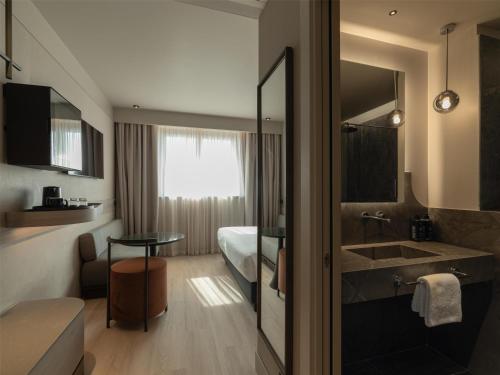 a hotel room with a bathroom with a sink and a bed at Best Western Hotel Rome Airport in Fiumicino