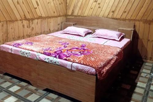 a bed with purple flowers on it in a room at Hotel priyanshu in Madheso