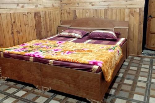 a large wooden bed in a wooden room at Hotel priyanshu in Madheso