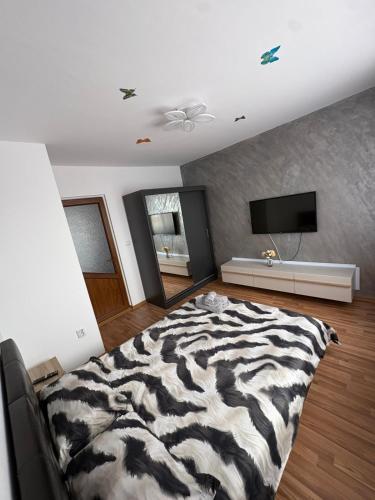 a zebra print bed in a room with a television at Apartament Eric in Mangalia