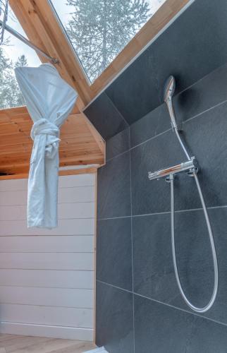 a shower in a bathroom with a roof at Alpin D'Hôme Hôtel & Spa in Les Orres