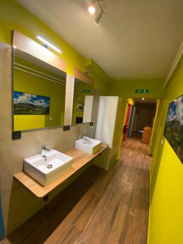 a bathroom with two sinks and a mirror at Hostel Soča Rocks in Bovec