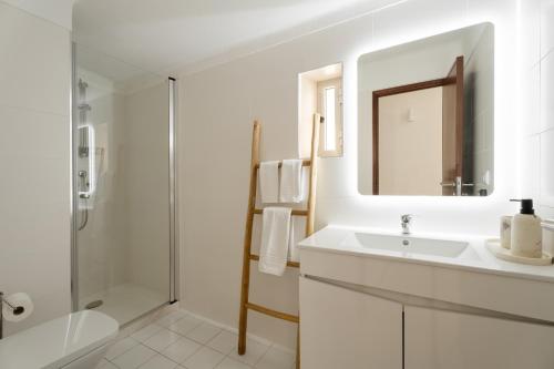 a white bathroom with a sink and a shower at Casa da Areia - by RowdHouses - Private Beach Access in Praia da Barra