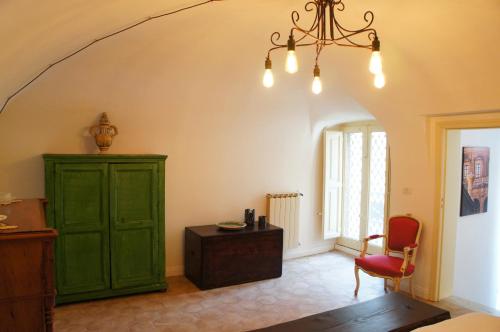 een kamer met een groene kast en een rode stoel bij Soffitta29 in Catania