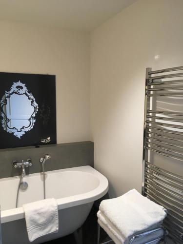 a bathroom with a bath tub and a sink at Port Rive Gauche Roseliere in Marseillan