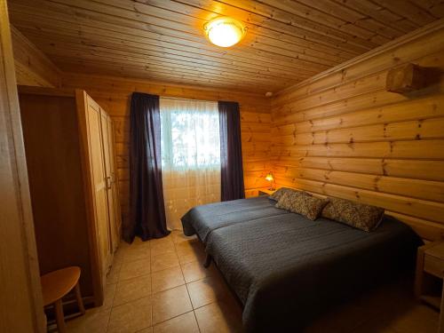 a bedroom with a bed in a wooden cabin at Jämsän Lomamökit in Jämsä