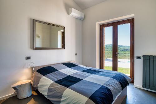 a bedroom with a bed with a mirror and a window at San Venanzo – Casale De' Conti in San Venanzo