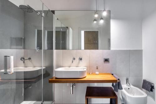 a bathroom with two sinks and two mirrors at San Venanzo – Casale De' Conti in San Venanzo