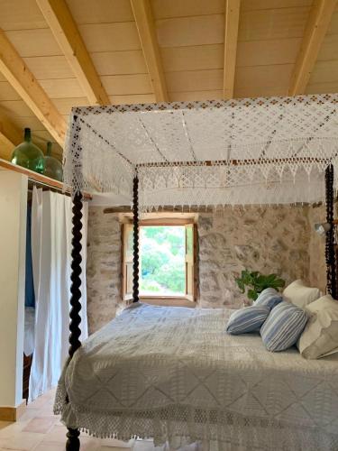 a bedroom with a canopy bed with a window at Can Peñes in Port d'Andratx