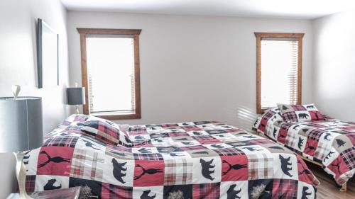 ein Schlafzimmer mit zwei Betten und zwei Fenstern in der Unterkunft Overlook in Valemount