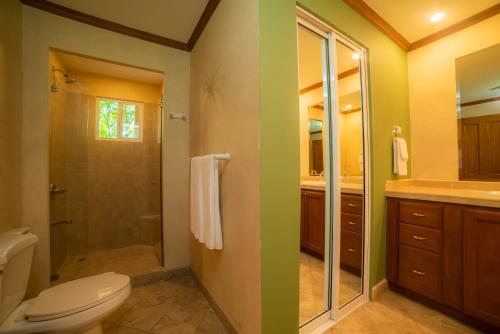 a bathroom with a toilet and a glass shower at Veranda 3G 2 bdr Garden View in Los Suenos in Jacó