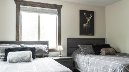 a bedroom with two beds and a deer picture on the wall at The Highmark Cabin in Valemount