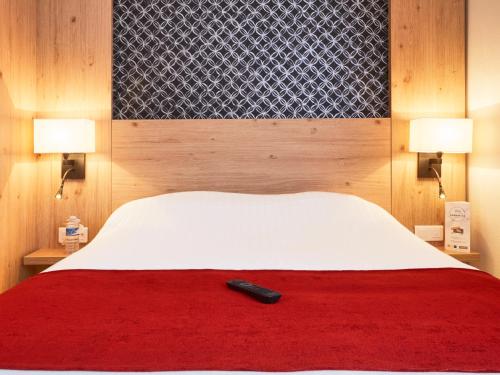 a remote control sitting on top of a bed at Kyriad Vannes Centre Ville in Vannes