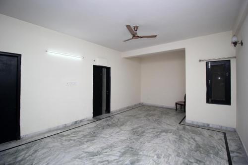 an empty room with a ceiling fan and a door at Hotel O Staysnap in Indirapuram