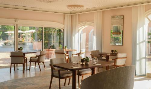 a restaurant with tables and chairs and windows at Villa Miraé by Inwood Hotels - Cap d'Antibes in Antibes