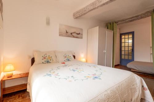 a bedroom with a large white bed with flowers on it at La Petite Maison in Puimoisson