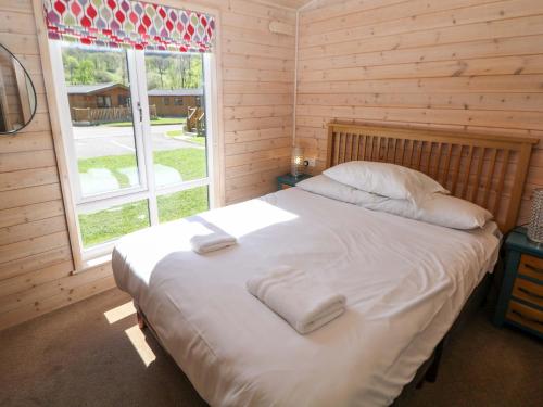 a bedroom with a large bed with towels on it at Dovestone Luxury Lodges sleeps 6 - pet free in Oldham