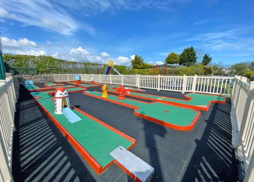 a childrens playground with a slide and a play park at Bryn Awel Caravan Park in Pentraeth