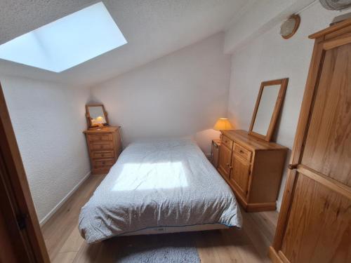 a bedroom with a bed and a dresser and a skylight at Duplex au calme vue montagne in Abondance