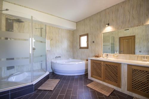 a large bathroom with a tub and a sink and a tub at Villa Valentina by Algarve Holidays in Almancil