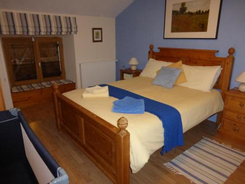 a bedroom with a large bed with blue sheets at L'Hirondelle Chambres d'Hotes in Saint-Mathieu