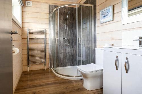a bathroom with a shower and a toilet at Pine Lodge Spa Pet in Thirsk