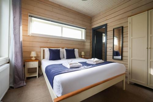 a bedroom with a large bed with a window at Pine Lodge Spa Pet in Thirsk