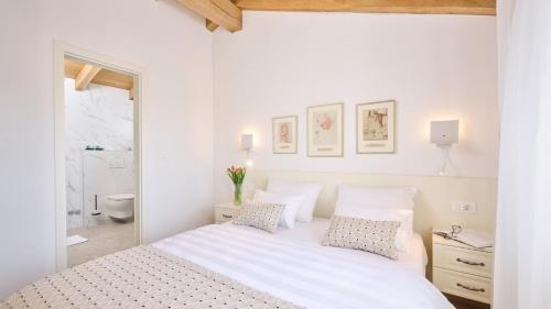 a white bedroom with a bed and a bathroom at Casa Pove by Villas Guide in Donje Baredine