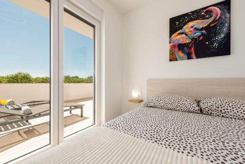 a bedroom with a bed and a large window at Villa Antonio ZadarVillas in Nin