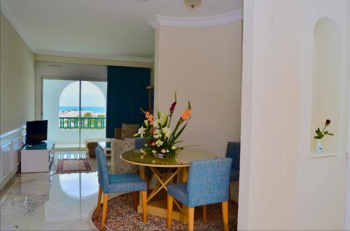 a living room with a table and chairs with a view at Royal Garden Palace - Families and Couples in Midoun