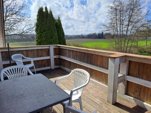 a patio with a table and chairs on a wooden deck at Ferienwohnung Morgenstern in Ausacker