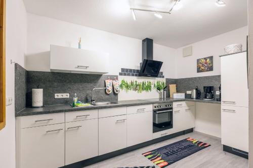 a kitchen with white cabinets and a stove top oven at Freigeist in Nesselwang