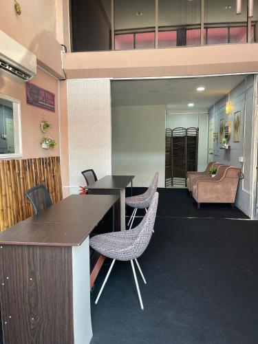 a lobby with two tables and chairs and a bed at Hotel O D'noor in Kota Bharu