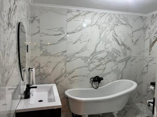 a bathroom with a white tub and marble walls at Maison De luxe in Thohoyandou