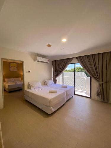 a large bedroom with two beds and a balcony at SWISS AVENUE HOTEL in Sungai Petani