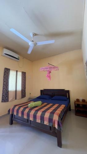 a bedroom with a bed and a ceiling fan at Romance in Bay in Arugam Bay