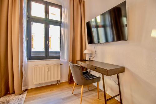 a desk and a chair in a room with a window at Zentral & ruhig - Stadt, Elbe und Natur nebenan in Magdeburg