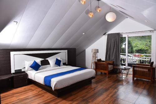 a bedroom with a large bed with blue pillows at GOLDEN GREEN RESORT WITH Pool in Munnar