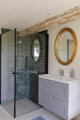 a bathroom with a shower with a sink and a mirror at Atma Guesthouse - cozy and simple farmhouse bed & breakfast in Marstal