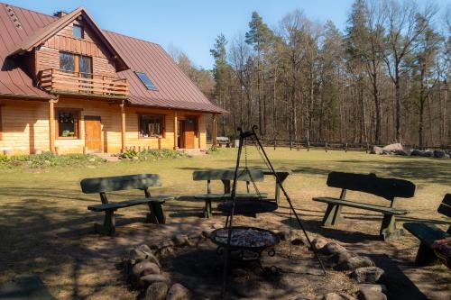 a fire pit in front of a log cabin at Na Wysokiej Górce- Agroturystyka in Grabowiec